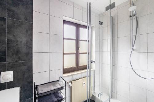 La salle de bains est pourvue d'une douche et d'une fenêtre. dans l'établissement Ferienwohnung Brunnenblick, à Pottenstein