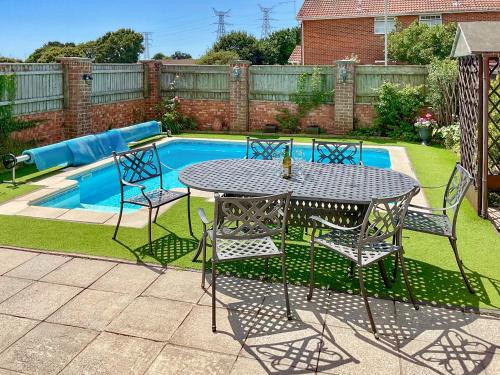 a table and chairs next to a swimming pool at Harbourside in Poole