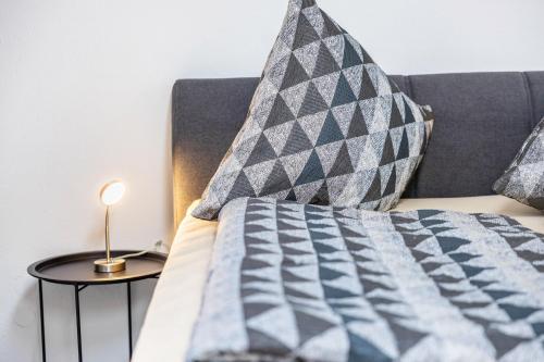 un lit avec une couette et des oreillers bleus et gris dans l'établissement Ferienwohnung Talblick, à Pottenstein
