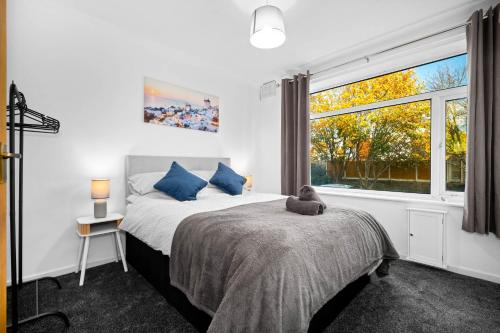 a bedroom with a bed and a large window at 4 Bedroom Town House Perfect for families or contractors Sleeps 8 in Halesowen