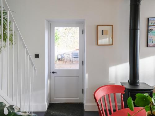 a hallway with a white door and a red chair at Sparrows Nest - Uk50109 in Longham