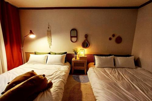 una camera con 2 letti e un cane steso sul letto di 스테이단 