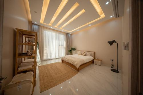 Un dormitorio con una cama y una ventana grande. en Private Home Gardens & Pools, Complementary tours and experiences inclusive, en Murayjāt