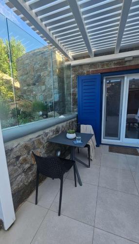 a patio with a table and a table and a bench at Idyllic Mykonos Suite w Jacuzzi and Sea Panorama in Houlakia