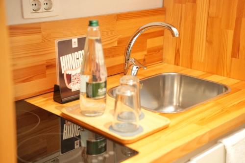 a kitchen counter with two bottles on a sink at Rooftop Tirana in Tirana