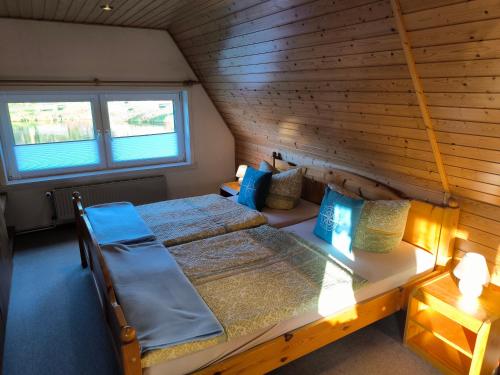 a attic bedroom with two beds and a window at Schwanensee Ferienhaus in Göhren