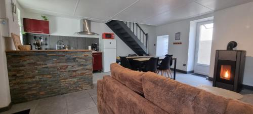 Una sala de estar con un sofá y una cocina. en Maison proche Grand Parc 2 Chambres, en Mauléon