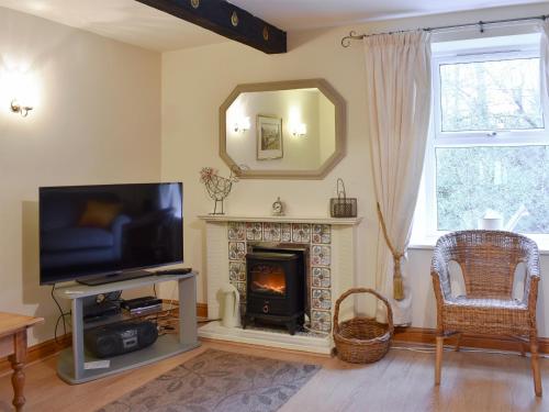 a living room with a fireplace and a television at Harriet's Hideaway in Braithwaite