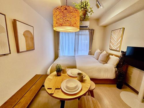 a bedroom with a bed and a table with plates on it at Hachioji House 206 Apartment in Hachioji