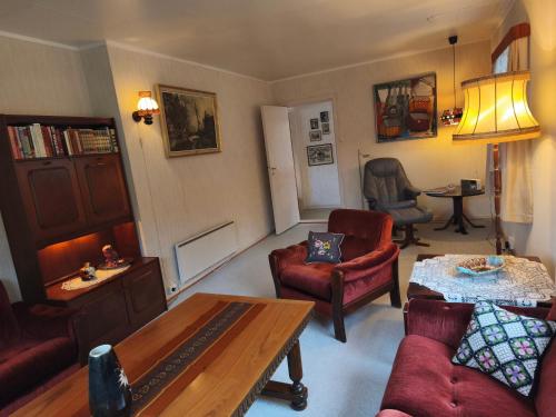 a living room with red furniture and a table at Room with Midnight-sun and Norhern-light View in Vestvågøya