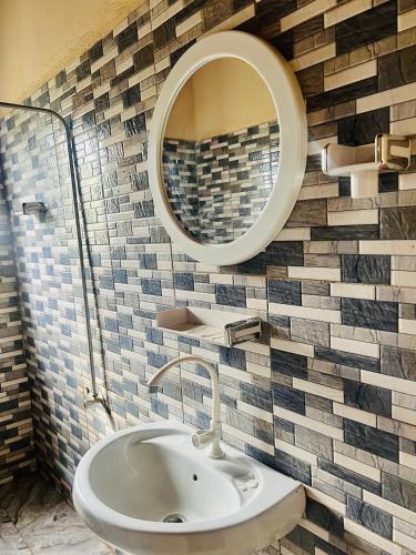 a bathroom with a sink and a mirror at Georgianas Residence in Kartung