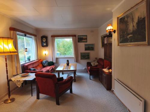 a living room with red chairs and a table at Room with Midnight-sun and Norhern-light View in Vestvågøya