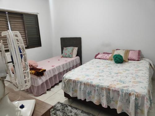 a bedroom with two beds and a window at Apartamento Larah in Cianorte