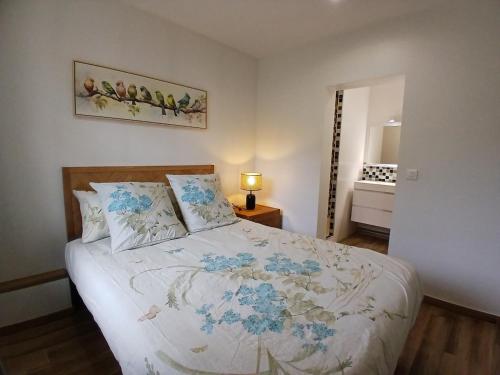 ein Schlafzimmer mit einem Bett mit blauen Blumen darauf in der Unterkunft Escapade Champêtre in Saint-Martin-en-Bière