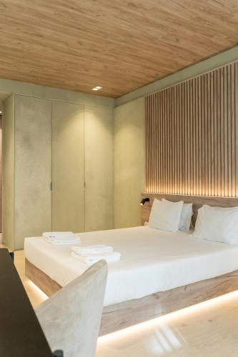 a bedroom with a large white bed with a wooden ceiling at ORM - Santa Teresa Apartments in Porto