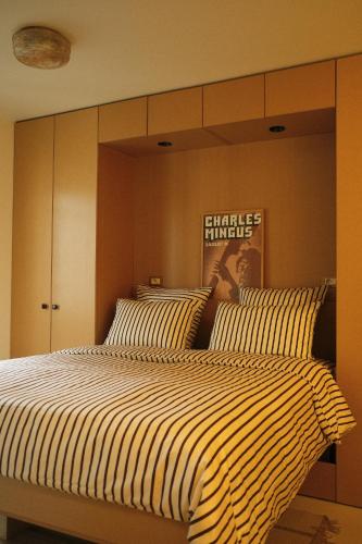 - une chambre avec un grand lit et des oreillers rayés dans l'établissement Les Reliefs de Montmartre, à Paris