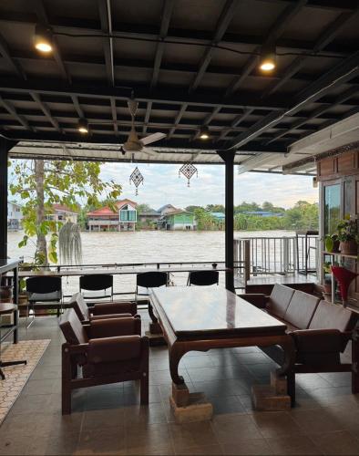 a patio with a table and chairs and a fountain at Baan Keang Chon Ayutthaya บ้านเคียงชล อยุธยา in Phra Nakhon Si Ayutthaya