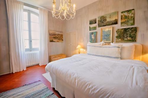 Luxurious Provencal Village House, Walk to Village Pool في روستريل: غرفة نوم بها سرير أبيض كبير وثريا