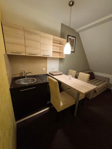 a small kitchen with a table and a sink at Apartments Suncani Vrhovi Kopaonik in Kopaonik