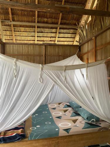 a bed in a hammock in a room at Mantorom homestay in Yennanas Besir