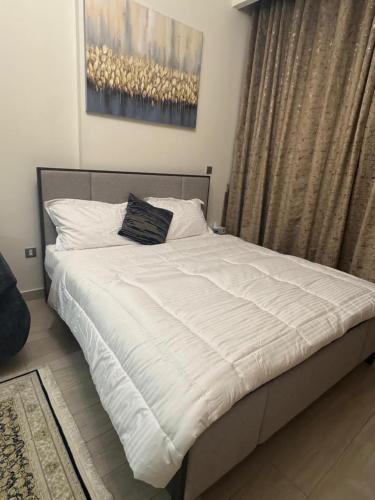 a bedroom with a large bed with white sheets at Sophisticated Studio Designer Interiors in Dubai
