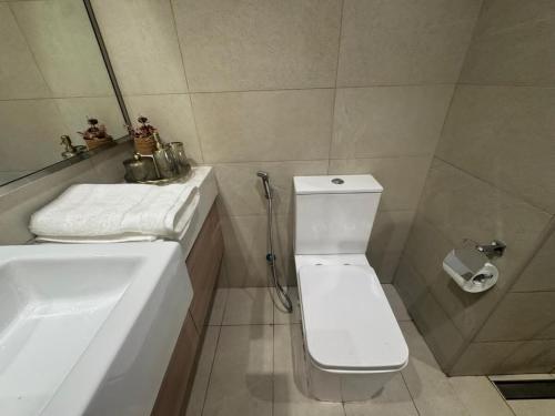 a bathroom with a white toilet and a sink at Sophisticated Studio Designer Interiors in Dubai