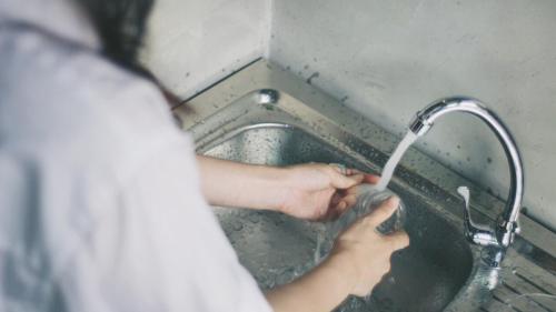 a person standing in a sink drinking from a faucet at Indiego Space in Loei
