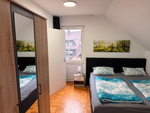 a small bedroom with two beds and a mirror at Fewo Zentral in Willingen