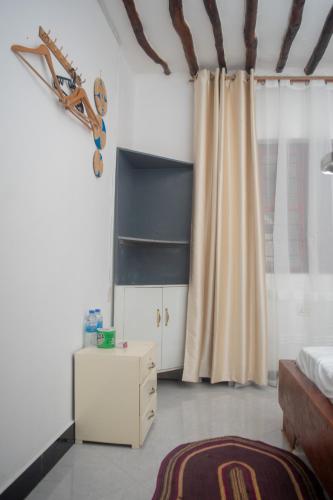 una camera da letto con un letto, un comò e una tenda di Mudi House a Jambiani