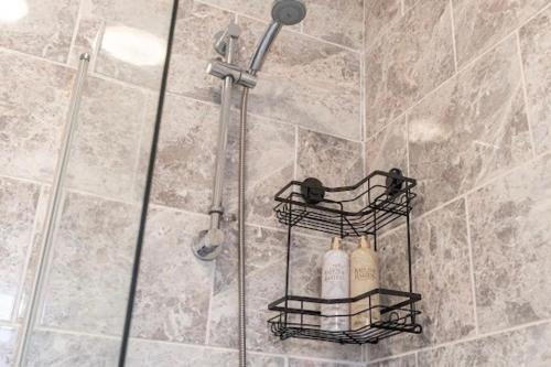 ein Bad mit einer Dusche und 2 Seifenflaschen in der Unterkunft La Casa de Class - Luxury & Comfort in Cardiff