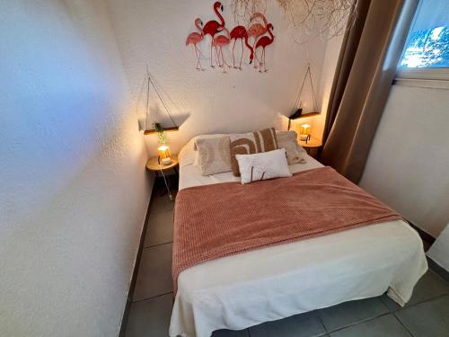 a small bedroom with a bed and two lamps at Magnifique T2 au calme avec une superbe vue sur le port in Canet-en-Roussillon