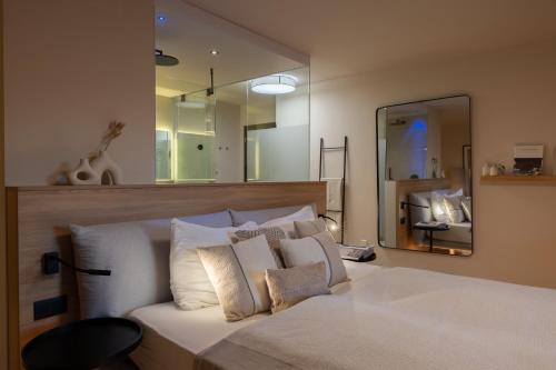 a bedroom with a white bed with a large mirror at Michael Am Waal in Schenna