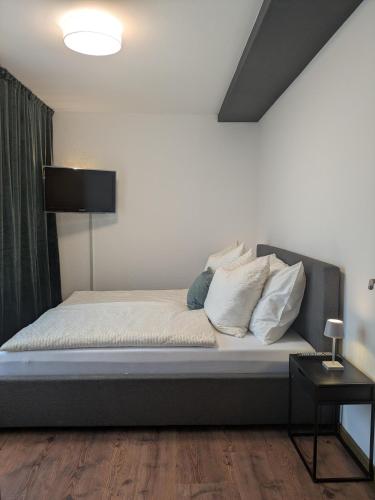 a bedroom with a bed with white sheets and pillows at Ferienwohnung Strizi in Ruhpolding