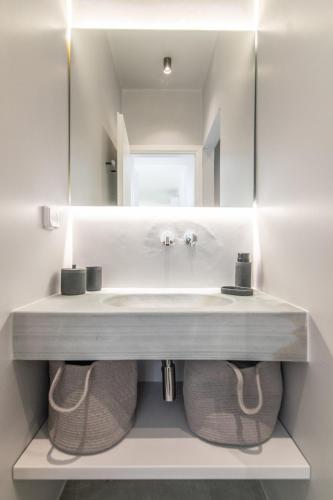 a bathroom with a sink and a mirror at Rockaine Suites Sunset in Agios Fokas