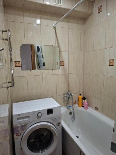 a bathroom with a washing machine and a sink at Cozy apartment in Kryvyi Rih