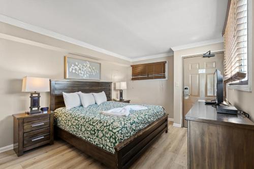 ein Schlafzimmer mit Bett, Schreibtisch und Fernseher in der Unterkunft Meridian Plaza 1401 in Myrtle Beach