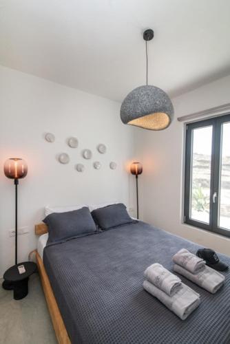 a bedroom with a bed with two pillows on it at Rockaine Suites Sunset in Agios Fokas