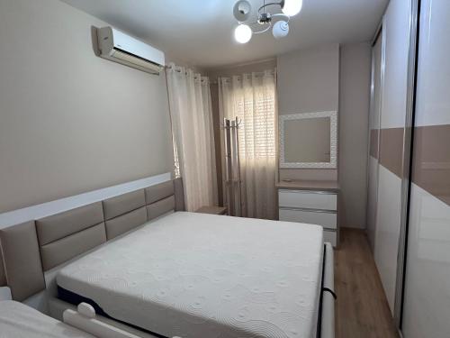 una piccola camera da letto con un letto e uno specchio di Livias a Kashari