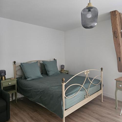 a bedroom with a bed with blue pillows at Chambre Cheverny, Casa 103 in Messas