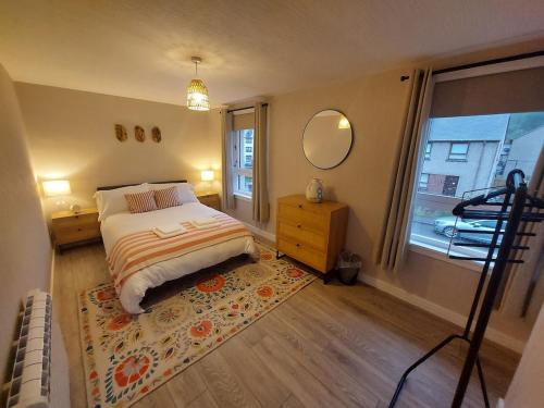 een slaapkamer met een bed, een spiegel en een raam bij 1 Carn Dearg in Fort William