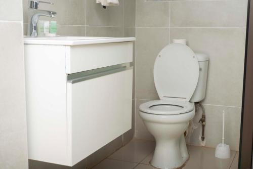 une salle de bain avec des toilettes blanches et un lavabo dans l'établissement Executive comfort with premium workspace - 2334, à Kwekwe