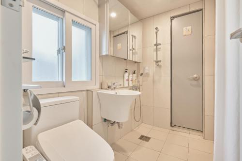 a bathroom with a toilet and a sink and a shower at Travel Home in Seoul