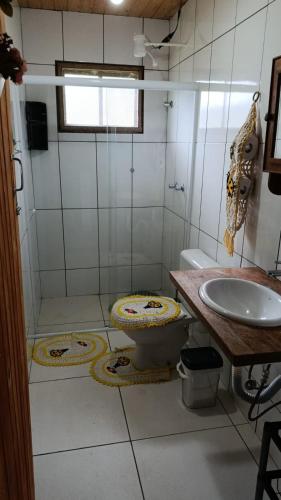 um banheiro com vaso sanitário e pia em Chacara Sossego em Monte Sião