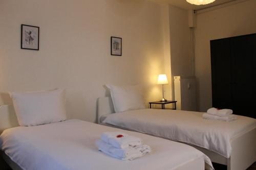 Zimmer im Zentrum mit drei Einzelbetten في بادربورن: سريرين في غرفة فندق مع مناشف عليهما