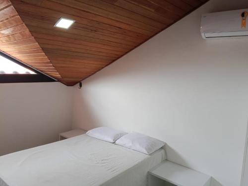 a small room with a bed and a wooden ceiling at Monte Castelo Flat Temporada in Gravatá