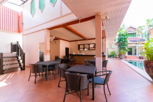 a patio with tables and chairs and a pool at The Elite Resort Pattaya in Pattaya South