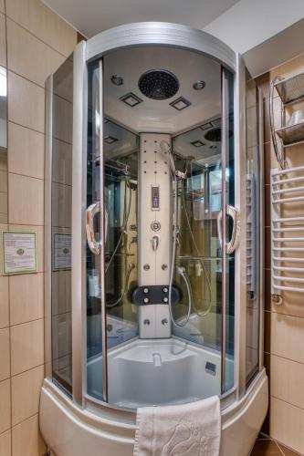 a bathroom with a tub with a large mirror at Hotel Muszyna in Muszyna