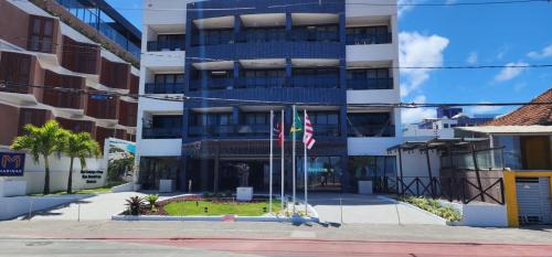 a building with two flags in front of it at Marinas Flat 420 in João Pessoa