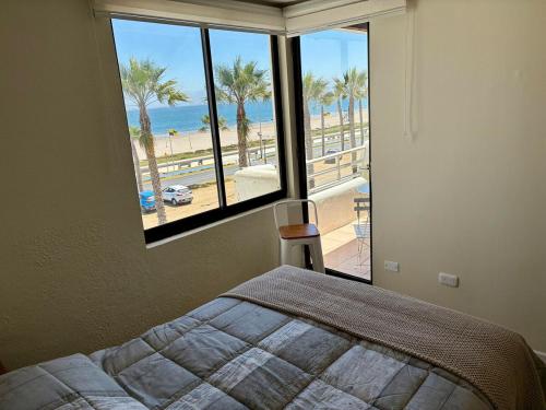 Departamento Borde Mar في كوكيمبو: غرفة نوم مع سرير وإطلالة على الشاطئ