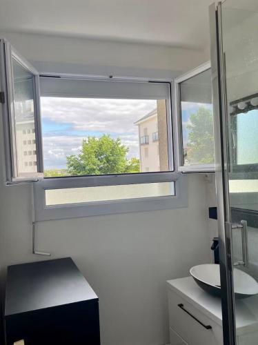 Un baño con una gran ventana y un lavabo. en Charmant T3 à Angers - parking gratuit, en Angers